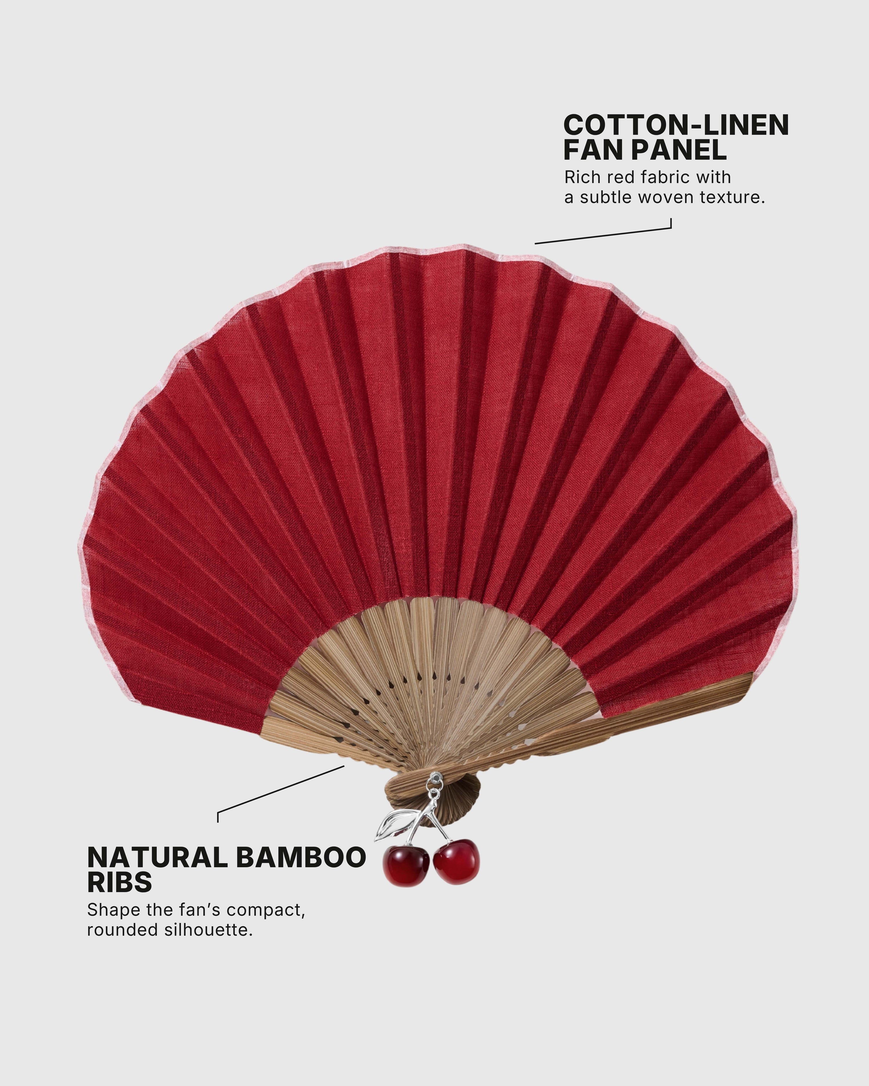 Open garnet hand fan showing textured cotton-linen panel and bamboo frame
