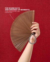 Espresso all-bamboo folding hand fan held against a warm background