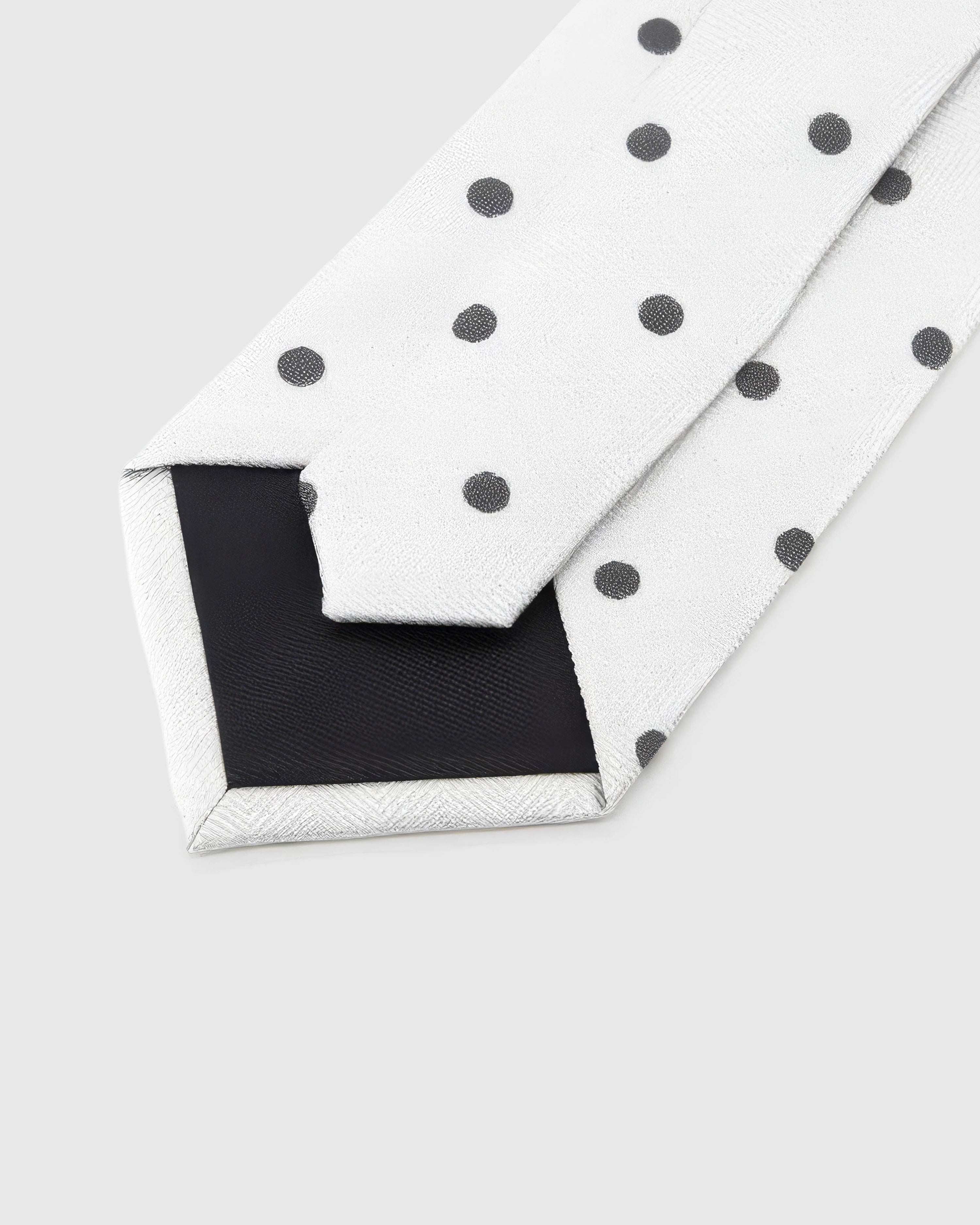 Back of STICKYZOO Pearl Onyx Dot Tie showing black structured interlining, hand-finished folds and keeper, 145 × 8 cm