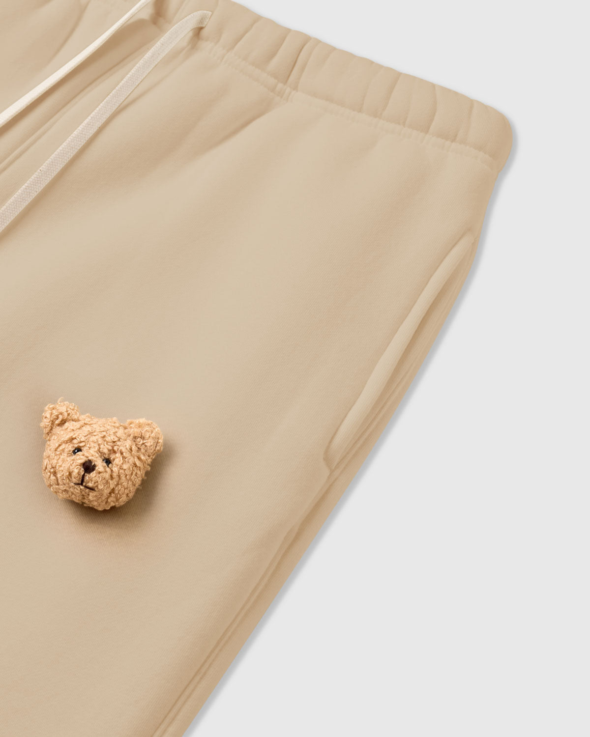 Detail of bear applique on STICKYZOO cream Sticky Bear Sweatpant showing tonal warmth