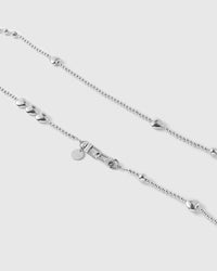 Close view of a graduated silver-tone bead cluster, puffy heart, dual clasp and engraved STICKYZOO disc.
