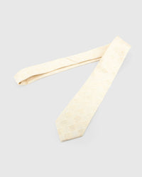 Ivory Gilded Grid Tie laid full length on white, showing an ivory field crossed by a pale-gold, softly irregular grid from blade to tail.