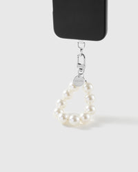White pearl wrist strap clipped to a black phone case for hands-free carry