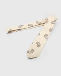Ivory Taupe Paisley Tie laid full length on white, showing an ivory ground with widely spaced taupe and brown paisley forms from blade to tail.