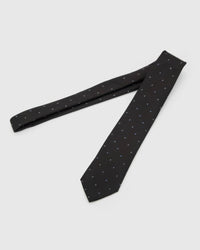 Noir Blue Icon Tie laid full length to show noir ground with small cobalt, azure and white abstract icons from blade to tail.