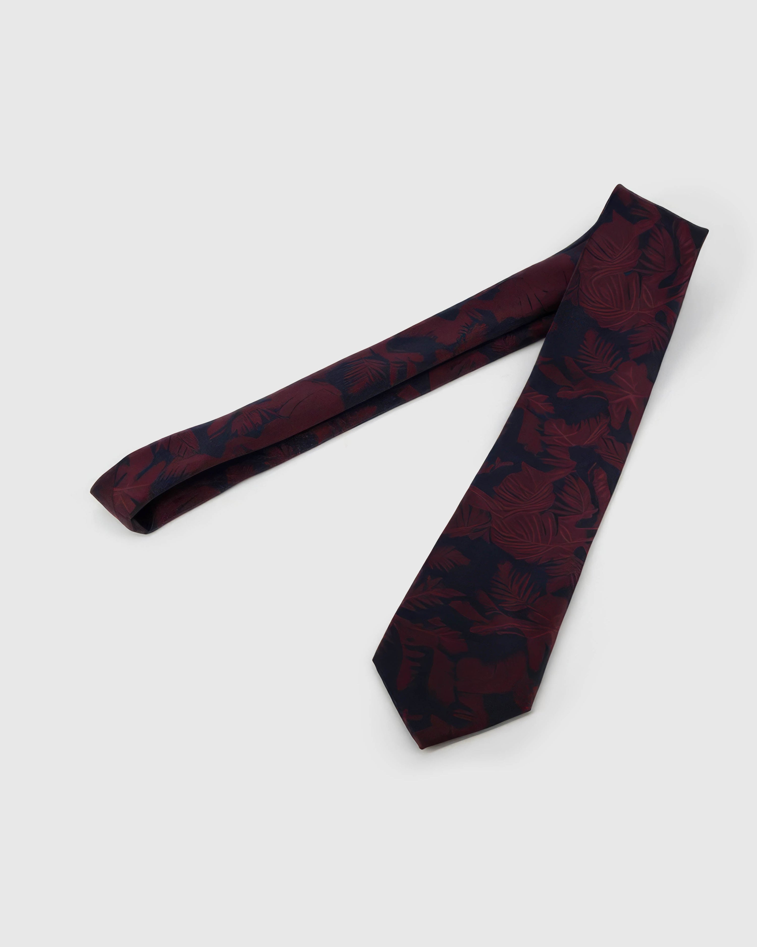 Full-length STICKYZOO Claret Shadow Bloom Tie showing midnight shadow blooms across a 145 × 8 cm hand-finished mulberry silk tie