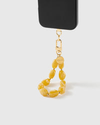 Amber marbled bead wrist strap clipped to a black phone case for hands-free carry