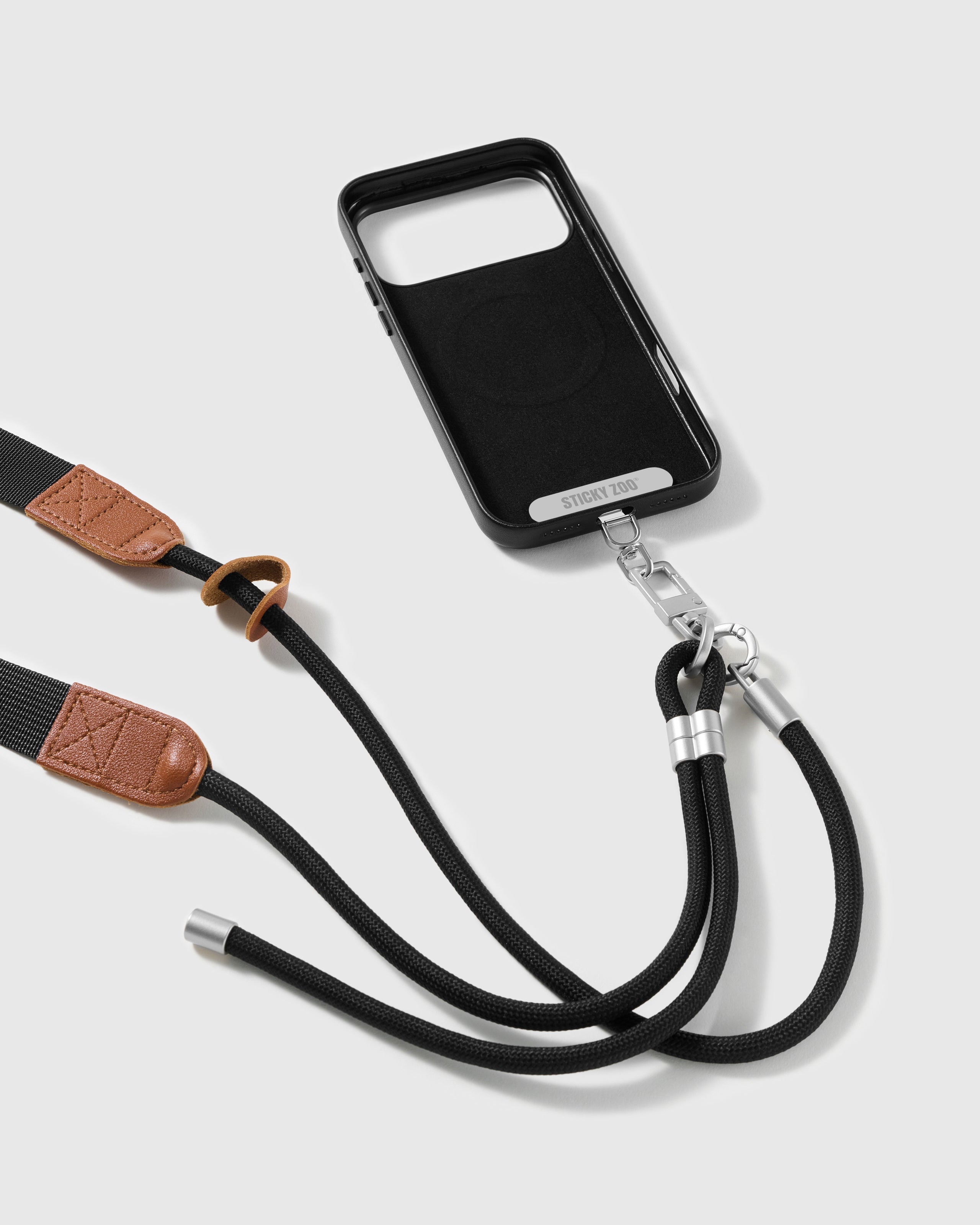 Black adjustable phone strap attached to a phone case with the sliding ring and stitched tan trim visible