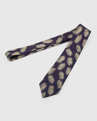 Aubergine Gilded Feather Tie laid full length on white, showing a deep aubergine ground scattered with slender pale-gold feathers from blade to tail.