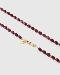 Macro close-up of the polished garnet resin beads and gold-plated clasp, each strap assembled by hand