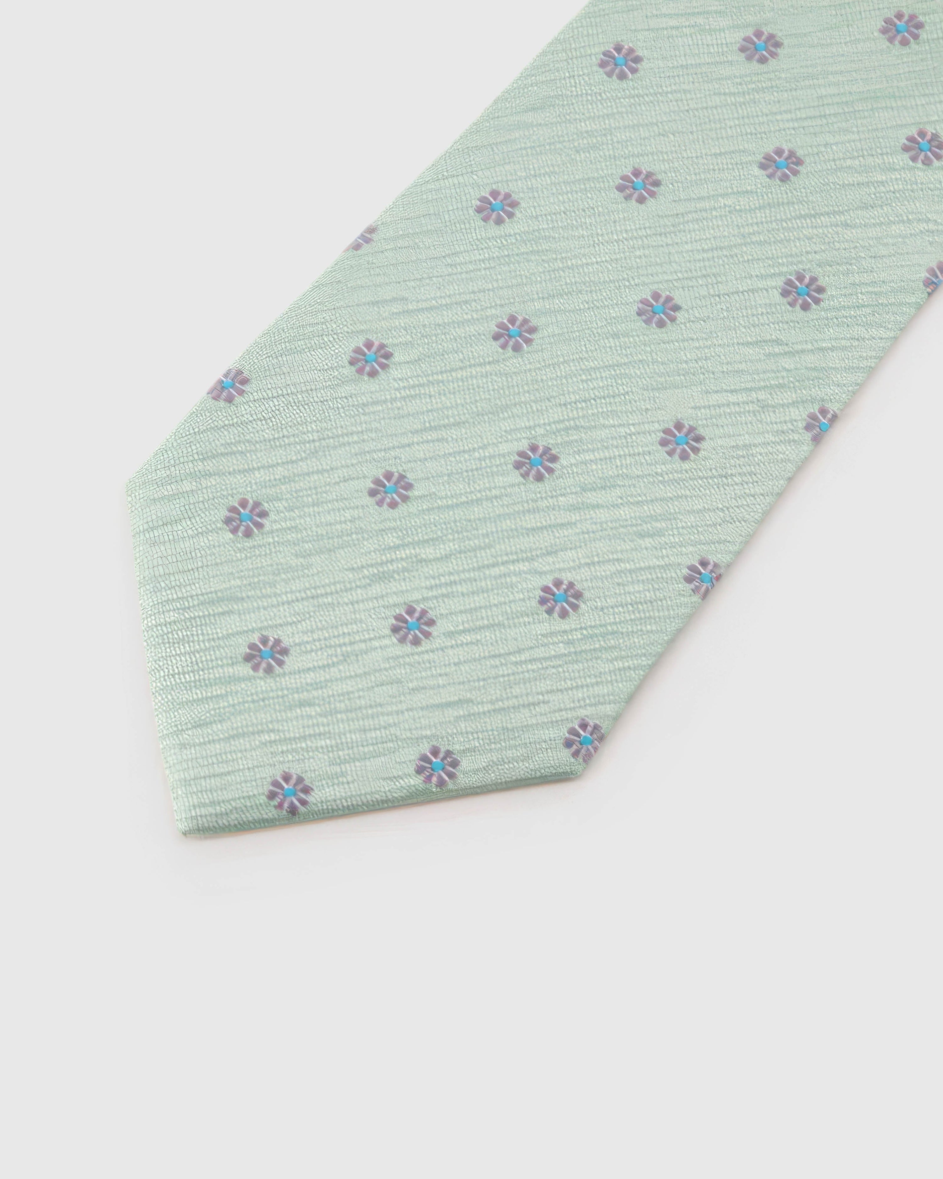 Sage Blossom Tie blade detail showing hand-embroidered mauve micro blossoms and silk texture by STICKYZOO