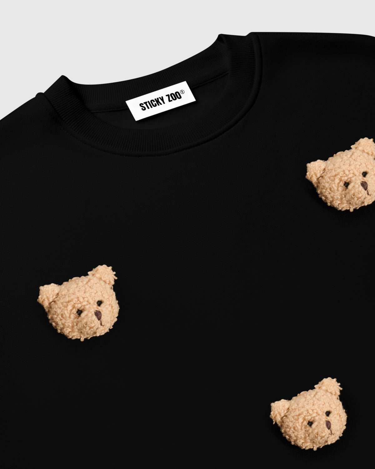 Flat-lay of Sticky Bear Sweatshirt in black with all six plush bears visible on premium cotton