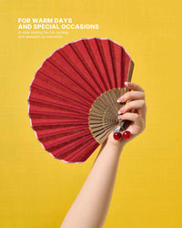 Garnet shell-shaped folding hand fan held against a yellow background