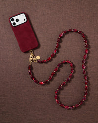 Garnet beaded cross-body phone strap styled on fabric, handmade not factory