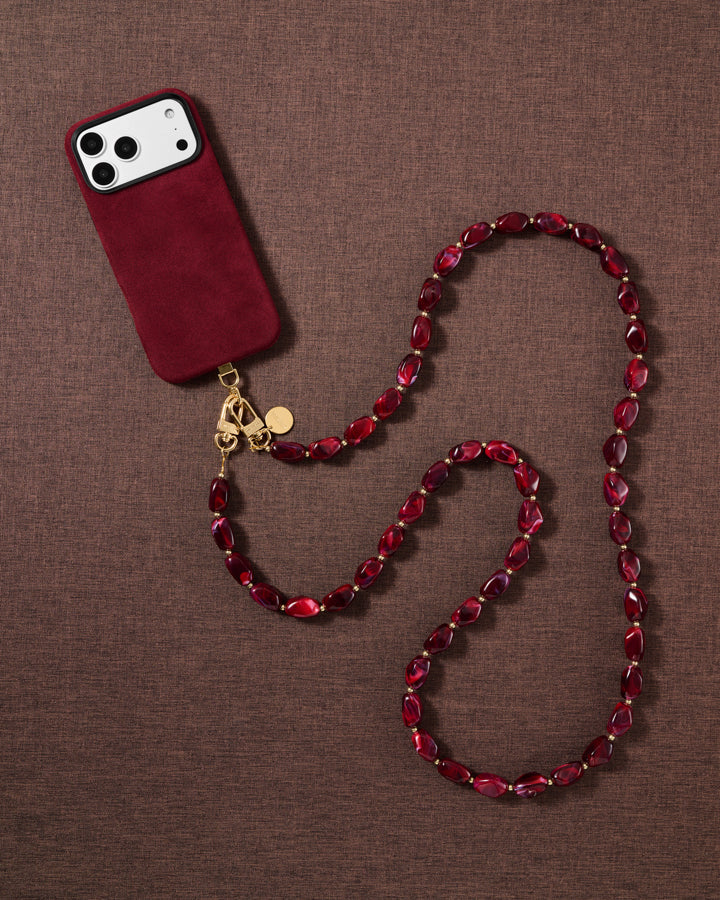 Garnet beaded cross-body phone strap styled on fabric, handmade not factory