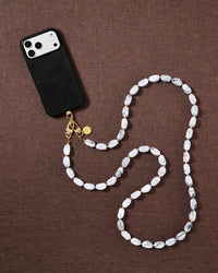 Marble beaded cross-body phone strap styled on fabric, handmade not factory