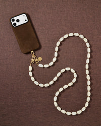 Ivory beaded cross-body phone strap styled on fabric, handmade not factory
