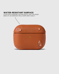 Water droplets beading on the Cognac AirPods case surface