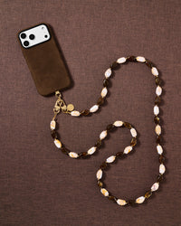 Tortoiseshell beaded cross-body phone strap styled on fabric, handmade not factory