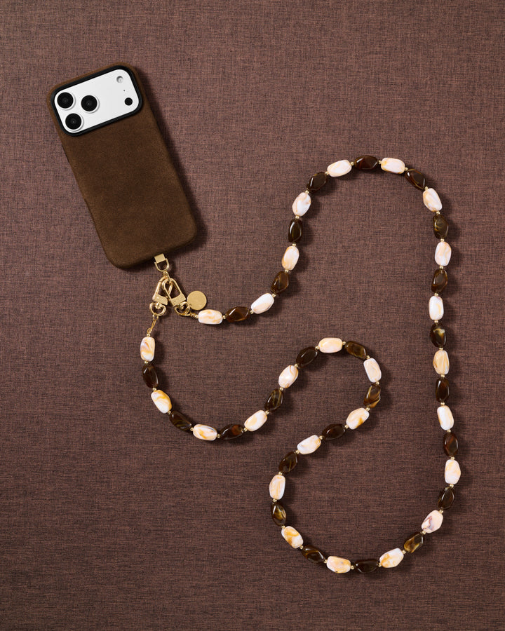 Tortoiseshell beaded cross-body phone strap styled on fabric, handmade not factory