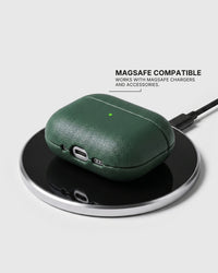 Green AirPods case on a wireless charging pad with text stating MagSafe compatibility