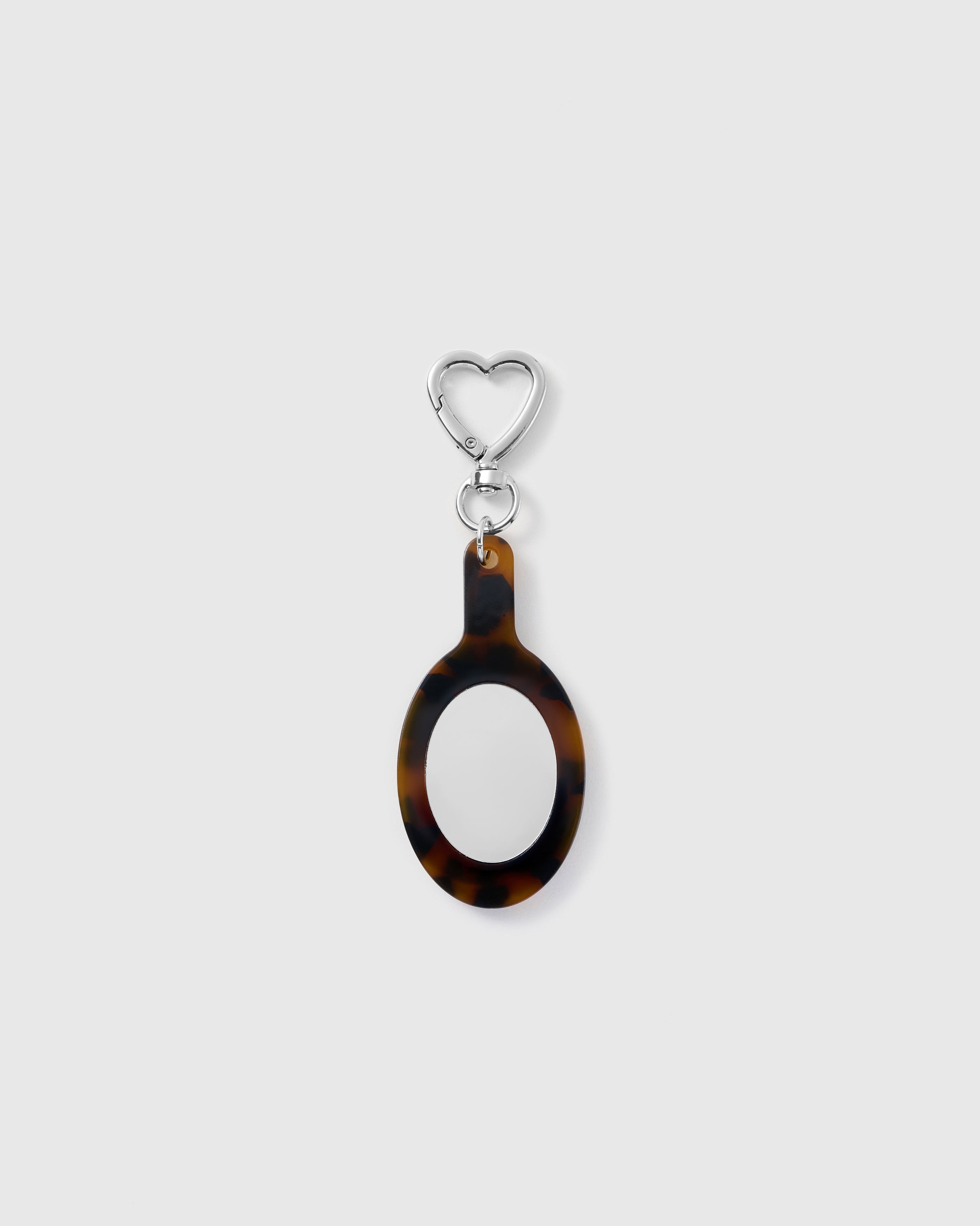 STICKYZOO Muse Pocket Mirror Charm with an elongated oval mirror, brown tortoiseshell-pattern frame and silver-tone heart-shaped clasp