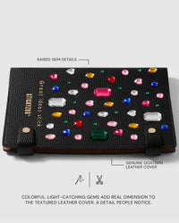 Raised multicolored gem details across the textured black goatskin leather cover of the Gemstone Notebook