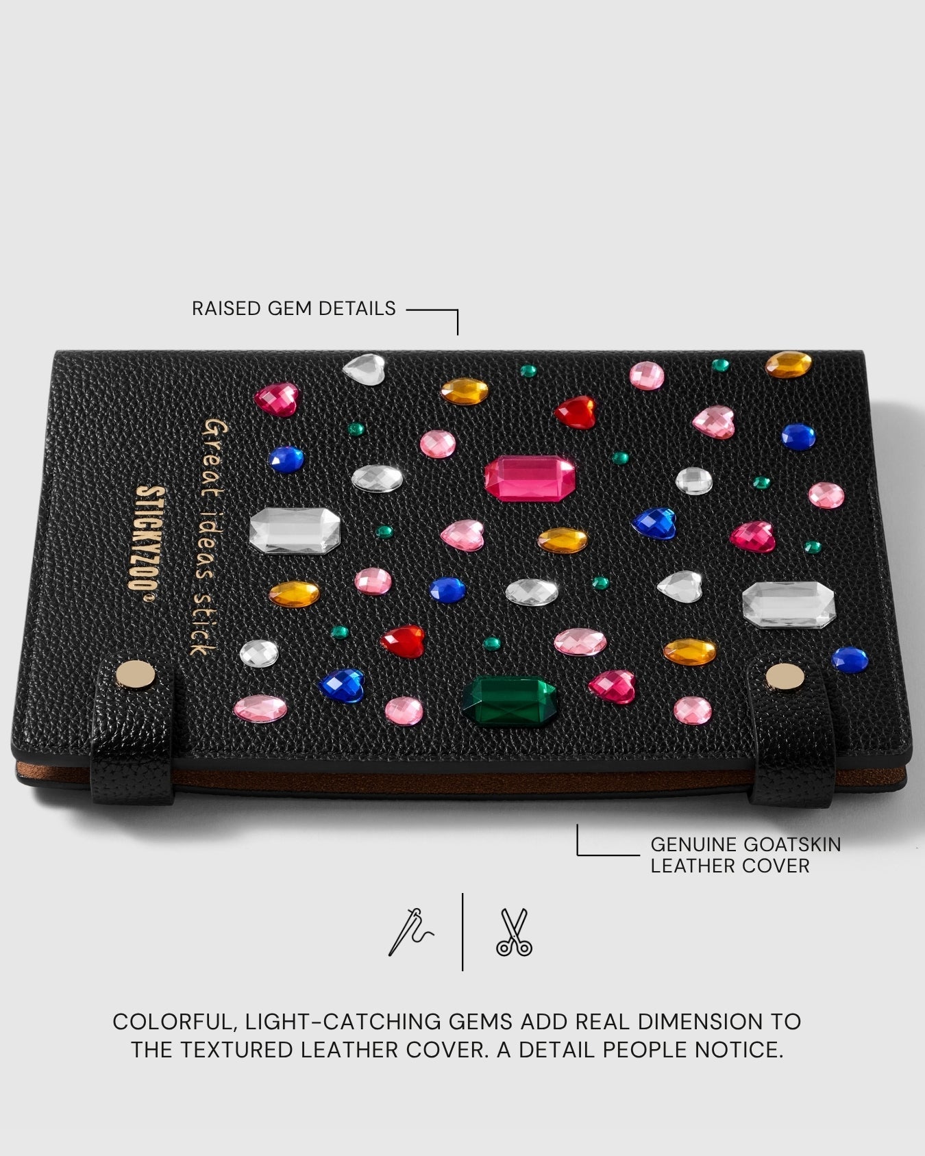 Raised multicolored gem details across the textured black goatskin leather cover of the Gemstone Notebook