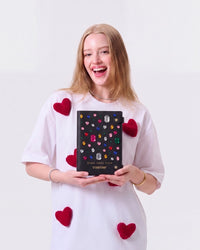 Model holding the closed STICKYZOO Gemstone Notebook with its raised colorful gem details visible