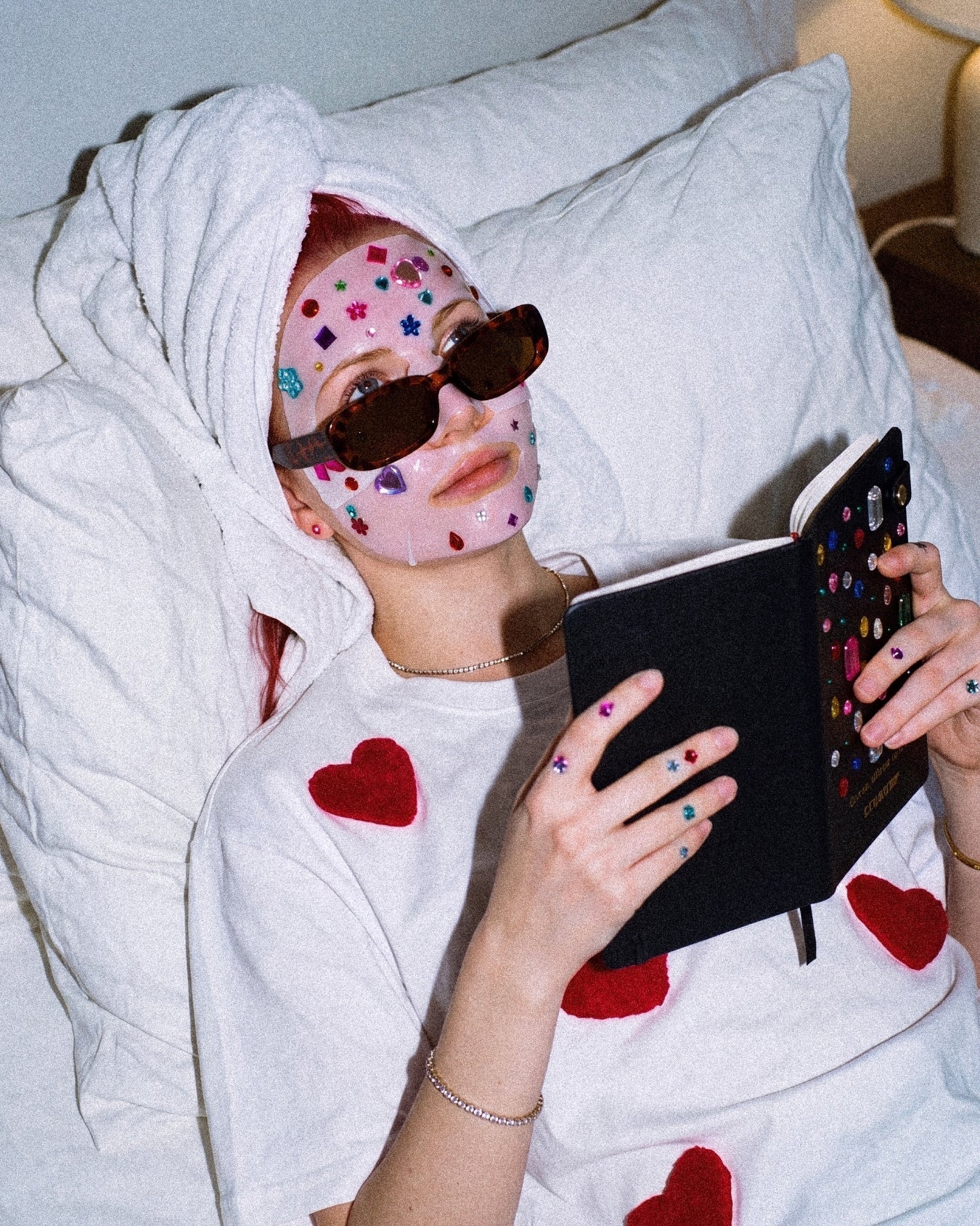 Person journaling with the open Gemstone Notebook and its raised multicolored cover details visible