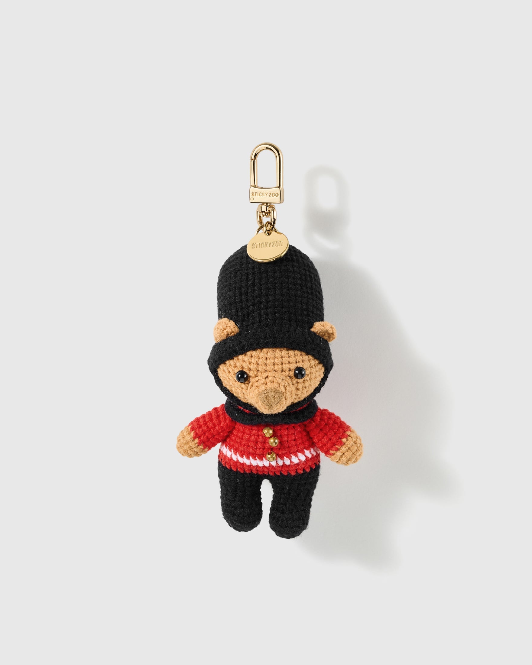 Royal Guard Bear Crochet Charm with a tall black hat, red uniform and black trousers create the recognisable guard silhouette on a light background